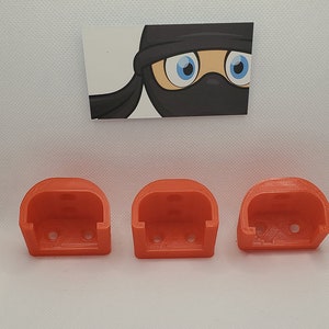 May include: Three bright orange plastic wall mounts, each with three holes for mounting screws.