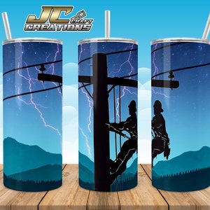 Könnte beinhalten: Drei Edelstahlbecher mit einem Design, das eine Silhouette eines Linienarbeiters zeigt, der an einer Stromleitung arbeitet, vor einem blauen Himmel mit Blitzen. Die Becher stehen auf einer Holzoberfläche.