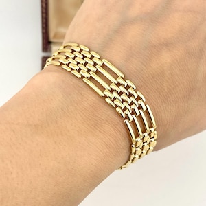 May include: A gold-toned bracelet featuring a multi-strand design with alternating sections of small, polished rectangular links and longer, slender horizontal bars that create an open, airy pattern across the wrist for a refined appearance.