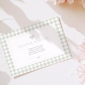Puede incluir: Tarjeta de rifa de pañales con estampado de cuadros vichy verde claro y blanco. La tarjeta tiene las palabras "DIAPER RAFFLE" en la parte superior, con un gráfico de corazón. La tarjeta también incluye texto sobre la rifa y un espacio para un nombre.