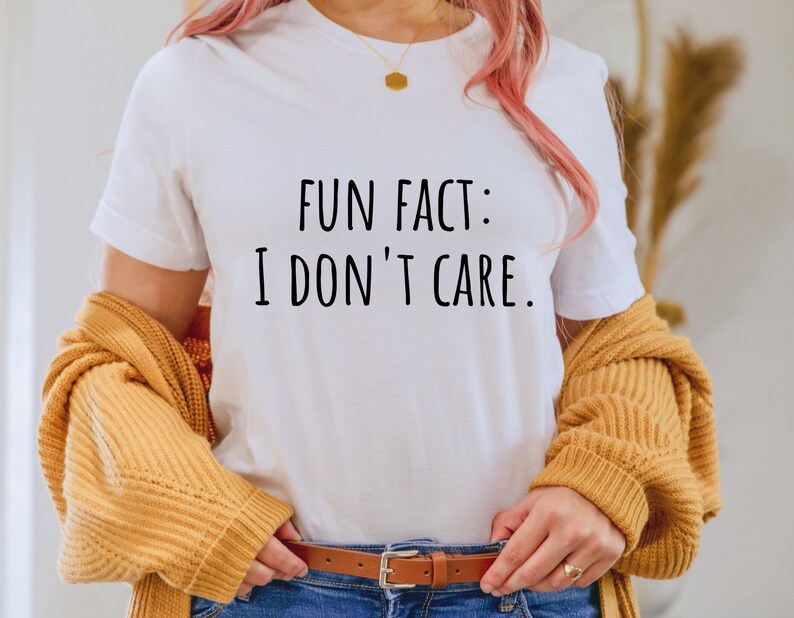 May include: White t-shirt with the text "FUN FACT: I DON'T CARE." printed in black.