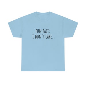 May include: A light blue t-shirt with the text "FUN FACT: I DON'T CARE." printed in black.