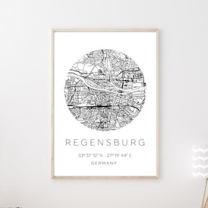 Könnte beinhalten: Schwarz-weiß Stadtplan-Druck von Regensburg, Deutschland mit den Koordinaten 49° 37' 12" N 27° 19' 44" E. Der Druck ist gerahmt und hängt an einer weißen Wand über einem Holz-Konsolentisch.