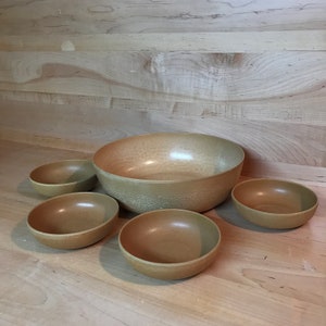 May include: Set of five brown plastic bowls, including a large serving bowl and four smaller bowls.