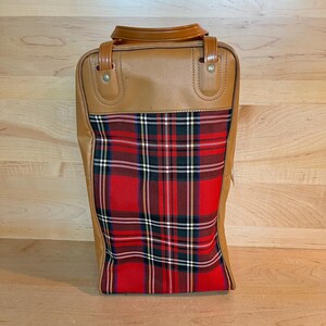 May include: A vintage suitcase with a brown leather top and handle. The lower section displays a red, black, green, and white tartan pattern. The rectangular suitcase is designed for travel and measures approximately 40cm in height.