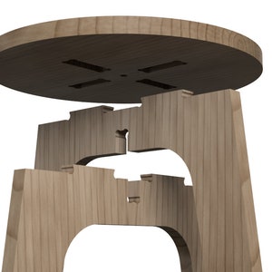 May include: A wooden stool disassembled into its individual parts, showing the interlocking design of the legs and the top. The top is round and has a small hole in the centre.