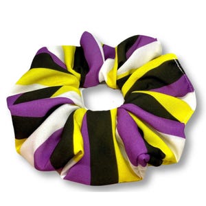 May include: Purple, yellow, black, and white striped scrunchie.
