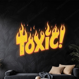 May include: A neon sign with the word "TOXIC!" in yellow, outlined in red, with flames above. The sign is mounted on a black wall with a leaf pattern. A black sofa, coffee table, and plants are in the foreground.