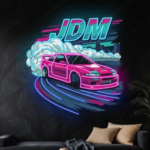 Pode incluir: Letreiro de néon com um carro desportivo rosa à deriva, com a palavra "JDM" em turquesa por cima. O carro é delineado em néon rosa, com raios azuis e rosa que indicam movimento. O fundo é uma paisagem urbana e fumo.