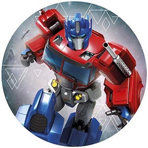 Pode incluir: Um robô vermelho e azul com uma arma, em pé sobre um fundo cinza com formas geométricas brancas. O robô tem uma cabeça azul com uma viseira preta e um corpo vermelho com detalhes amarelos. O texto "©2018 Hasbro" é visível no canto inferior esquerdo.