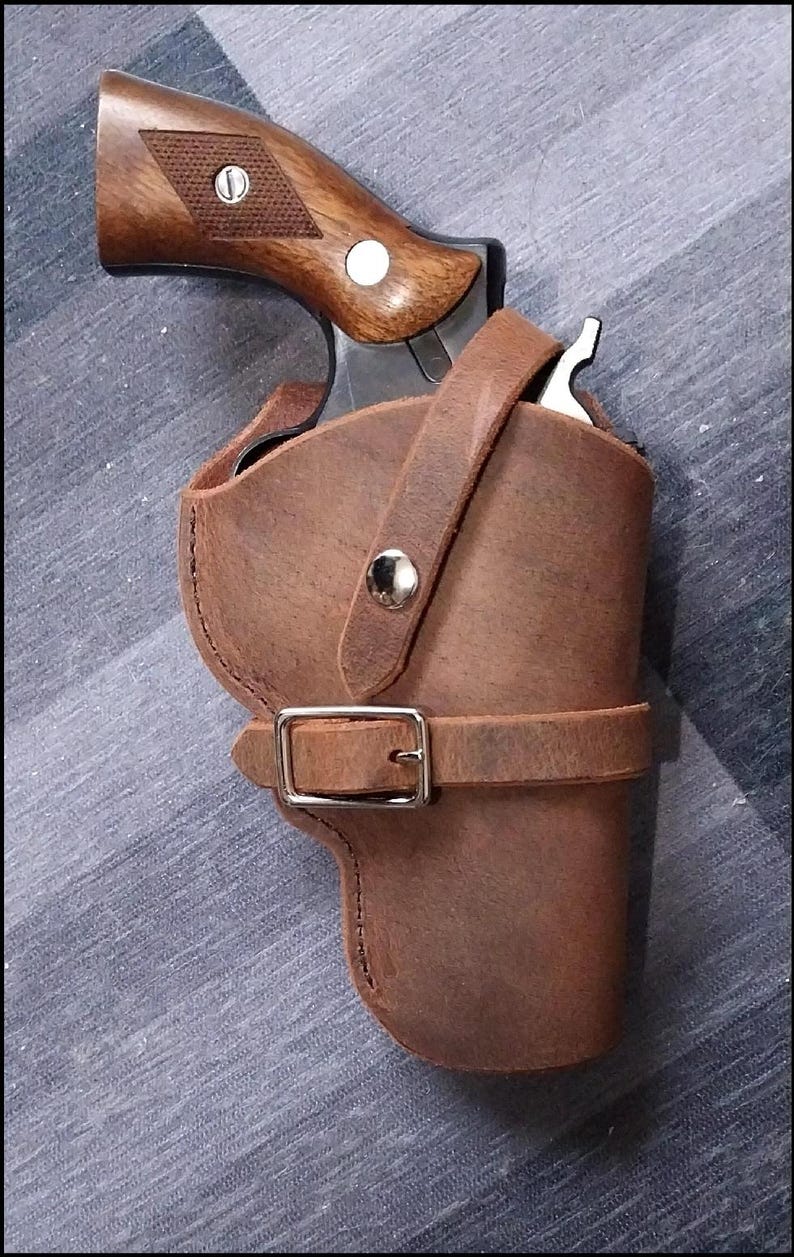 May include: A brown leather holster with a belt loop and a snap closure. A revolver is inside the holster.