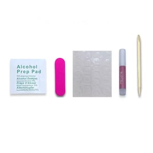 Peut inclure: Un ensemble d'accessoires pour les ongles comprenant une lime &agrave; ongles rose, une feuille transparente de pastilles adh&eacute;sives pour ongles, un flacon de colle &agrave; ongles, un pousse-cuticules en bois et un petit paquet blanc de tampons imbib&eacute;s d'alcool. Le paquet de tampons imbib&eacute;s d'alcool porte l'inscription "Alcohol Prep Pad" et "70% Isopropyl Alcohol".