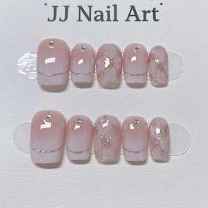 May include: Two sets of artificial nails. Each nail is a light pink color with a silver glitter accent. Some nails have a silver gem at the base. The text "JJ Nail Art" is at the top of the image.
