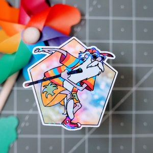 May include: A colorful sticker featuring a cartoon character with a long white beard, wearing sunglasses and a rainbow shirt, holding a stick and walking on a beach with palm trees. The sticker has a holographic background.