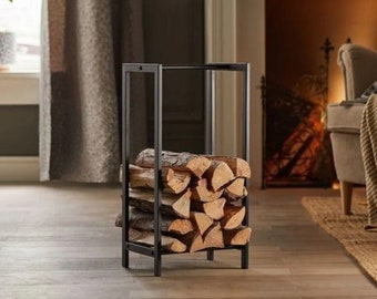 Puede incluir: Un soporte de leña de metal negro lleno de troncos apilados. El soporte tiene un diseño de marco rectangular y está colocado sobre un suelo de madera. Los troncos son de color marrón claro y tienen vetas naturales.