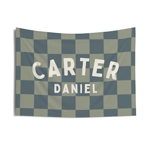May include: A green and blue checkered fabric banner with the name "CARTER DANIEL" in white text.