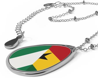 May include: A silver-toned oval pendant necklace featuring the flag of Sao Tome and Principe, which consists of green, yellow, and red horizontal stripes with a white triangle on the left side and two black stars centered within the yellow stripe.