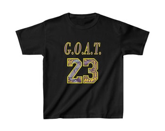 May include: Black t-shirt with the text "G.O.A.T. 23" in yellow and purple. The number 23 is filled with a collage of words and images. The shirt is made of a soft material and is suitable for everyday wear.