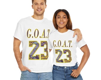May include: Two white t-shirts with a purple and yellow graphic of the number 23 and the text "G.O.A.T." printed on them.