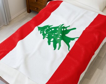 May include: A white blanket with red borders and a green cedar tree emblem in the center, representing the flag of Lebanon. The blanket is draped over a bed, showcasing the design.