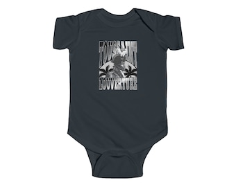 May include: A dark blue baby onesie with a white graphic of Toussaint Louverture, a historical figure, with palm trees and the text "Toussaint Louverture".