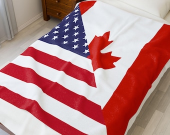 May include: A white blanket with a design that combines the flags of the United States and Canada. The American flag portion features red and white stripes and a blue field with white stars. The Canadian flag portion has a red maple leaf.