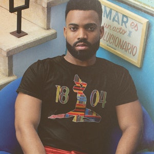 May include: A person wearing a black t-shirt with a colorful graphic of a woman and the numbers "18 04".