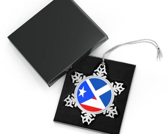 May include: A snowflake-shaped Christmas ornament with a Puerto Rican flag design. The ornament is silver-colored and comes in a black gift box. The flag features a white star, blue triangle, and red and white stripes.