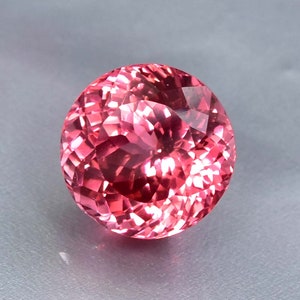 K&ouml;nnte beinhalten: Ein runder, facettierter rosa Edelstein mit hohem Glanz.