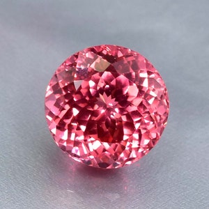K&ouml;nnte beinhalten: Ein runder, facettierter rosa Edelstein mit einem brillanten Glanz.