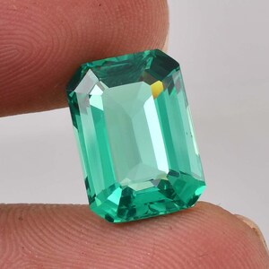 Op de afbeelding: Een levendige groene smaragd geslepen edelsteen met een hoge glans en facetten.