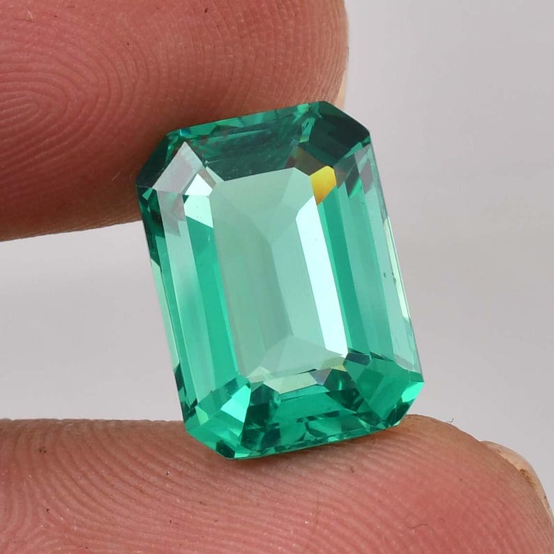 Op de afbeelding: Een levendige groene smaragd geslepen edelsteen met een hoge glans en facetten.