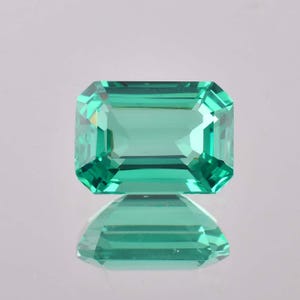 Op de afbeelding: Een levendige groene smaragd edelsteen geslepen in een smaragd vorm. De edelsteen is gefacetteerd en heeft een hoge mate van helderheid.