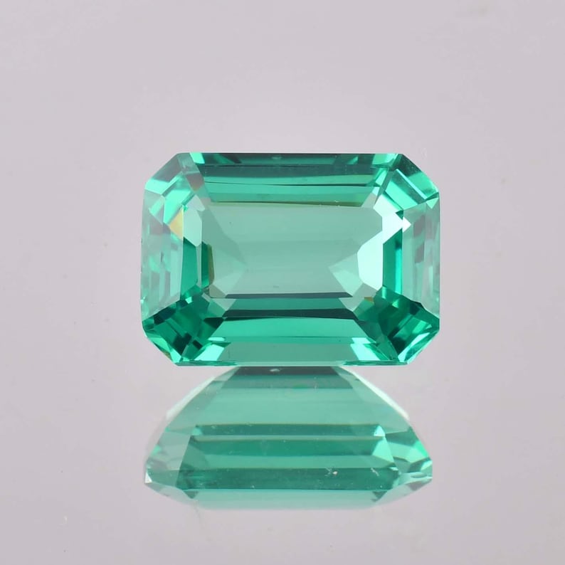 Op de afbeelding: Een levendige groene smaragd edelsteen geslepen in een smaragd vorm. De edelsteen is gefacetteerd en heeft een hoge mate van helderheid.