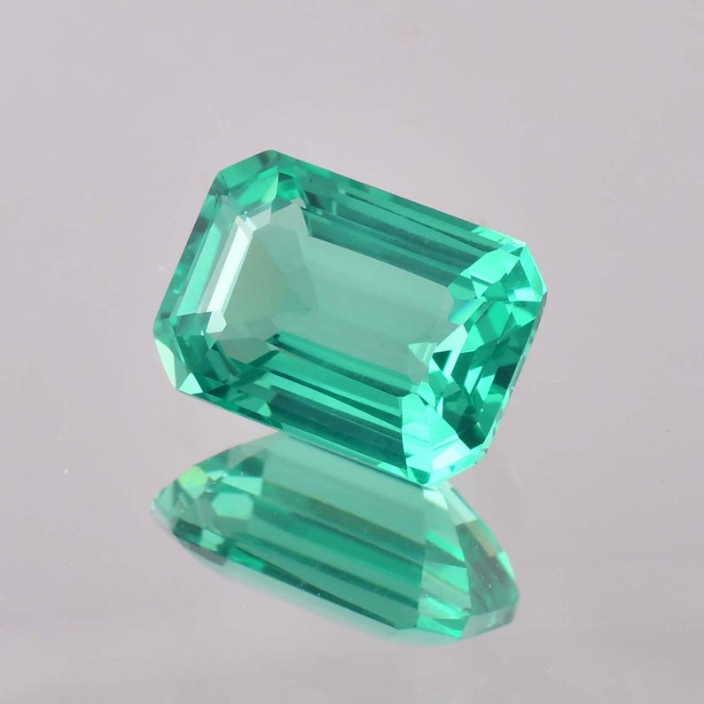 Op de afbeelding: Een levendige groene smaragd edelsteen geslepen in een smaragd vorm. De edelsteen is gefacetteerd en heeft een hoge mate van helderheid.