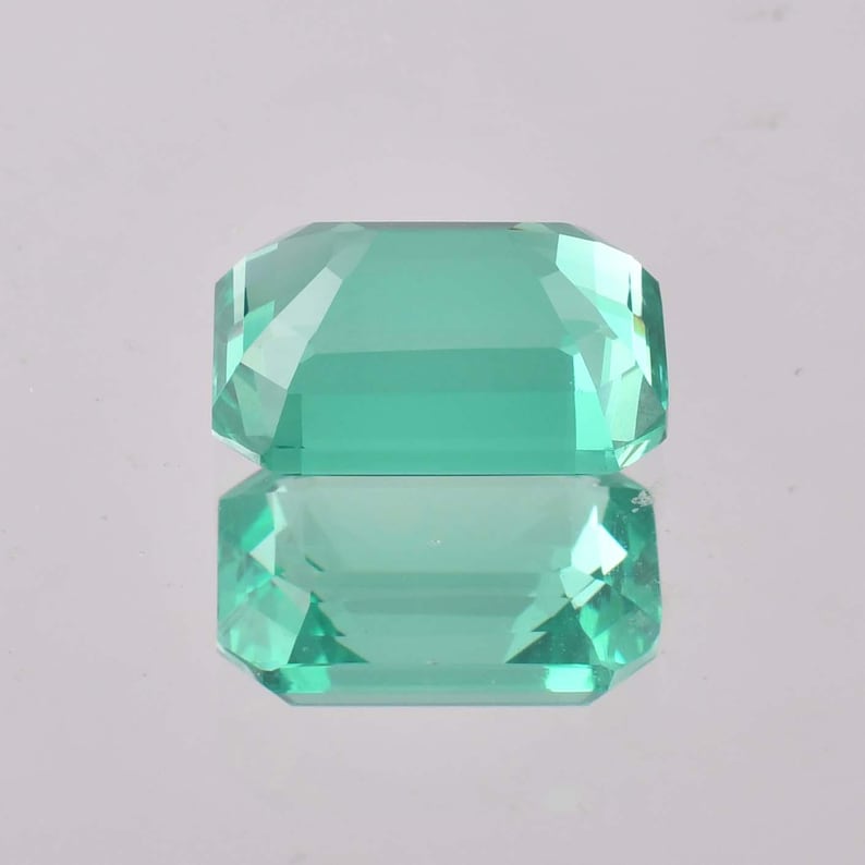 Op de afbeelding: Een lichtgroene smaragd geslepen edelsteen met een hoge glans.