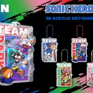 Könnte beinhalten: Ein Set mit vier 3D-Acryl-Schlüsselanhängern mit Charakteren aus dem Videospiel Sonic Heroes. Jeder Schlüsselanhänger zeigt ein anderes Team: Team Sonic, Team Dark, Team Chaotix und Team Rose. Die Schlüsselanhänger sind transparent und zeigen die Charaktere in einem Cartoon-Stil.