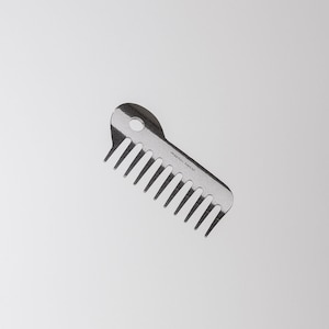 May include: A silver comb with a rounded handle and a row of teeth. The comb has the text "made in Japan" printed on the handle.