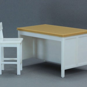 Op de afbeelding: Een wit bureau met een lichtbruin blad en een witte stoel. Het bureau heeft een eenvoudig ontwerp met een rechthoekig blad en een enkele lade. De stoel heeft een eenvoudig ontwerp met een rechthoekige zitting en een rugleuning.