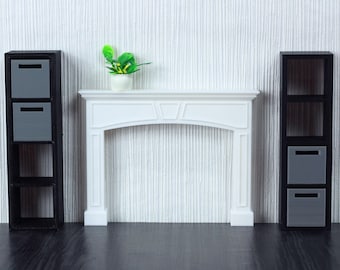 May include: A white fireplace mantel with a black shelf unit on each side. The shelf units have three shelves each and are filled with gray boxes. A small green plant sits on top of the mantel.