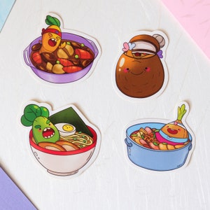 Op de afbeelding: Vier kleurrijke stickers met cartoonfiguren in kommen met verschillende Aziatische noedelgerechten. De figuren zijn groenten met gezichten en genieten van hun maaltijden.