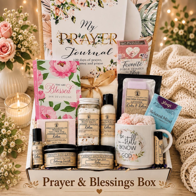 May include: A gift box labeled Prayer & Blessings Box containing a My Prayer Journal, a You Are Blessed devotional, a box of Bible verses, bath salts, body lotion, shower steamers, a mug with text, a candle, sugar scrub, lip balm, and soap.