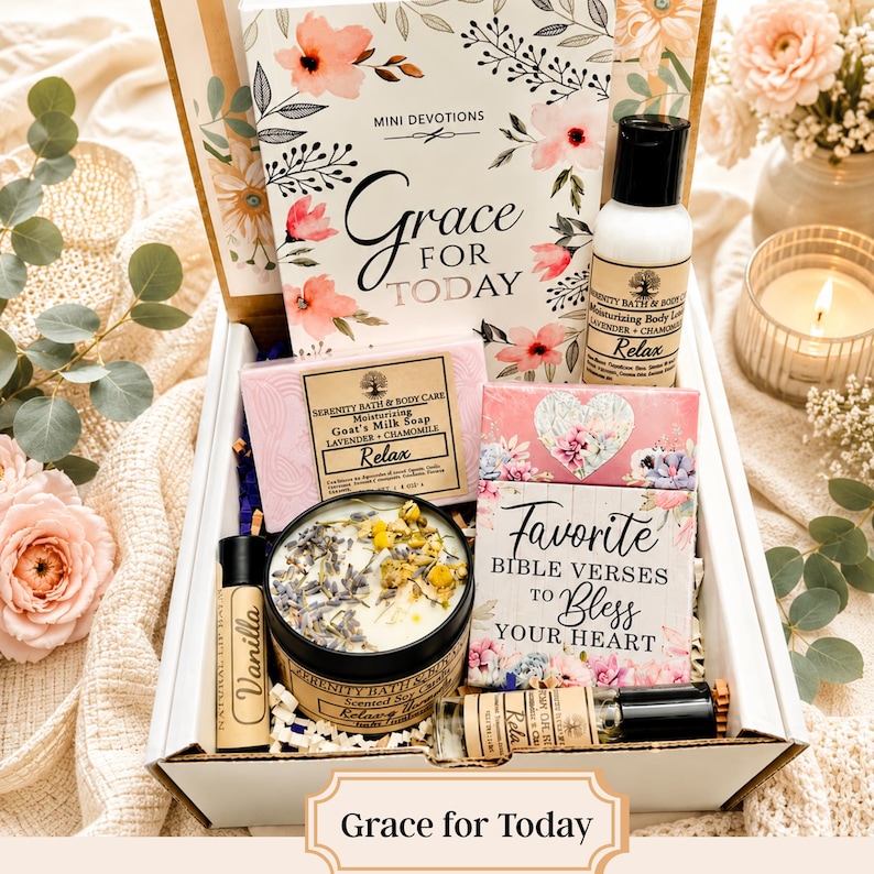 May include: A gift box containing a Mini Devotions Grace for Today book, a bottle of lavender and chamomile body lotion, a bar of goat's milk soap, a candle topped with dried flowers, a vanilla lip balm, and a Favorite Bible Verses book.