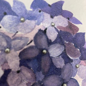 May include: A close-up of a watercolor painting of purple flowers with silver glitter accents.