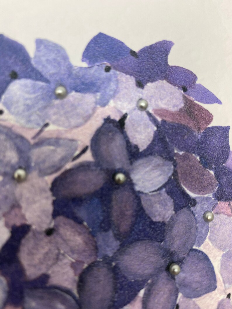 May include: A close-up of a watercolor painting of purple flowers with silver glitter accents.