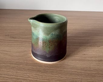 Small, handless jug glazed in greens and browns