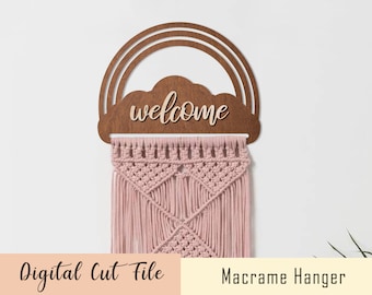 May include: A wooden rainbow and cloud cutout with the word "welcome" on it. A pink macrame hanger is hanging from the cutout.