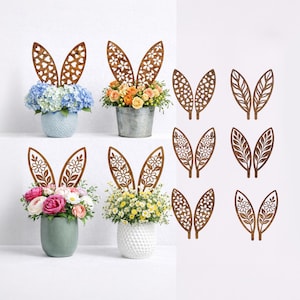May include: Wooden bunny ear decorations with floral cutouts, displayed in various arrangements. The ears are placed in pots of flowers, including hydrangeas, roses, and daisies. Additional pairs of ears are shown separately.