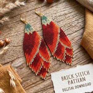 May include: Handmade beaded earrings in red, orange, and gold, with a green top. The earrings are leaf-shaped and have gold-coloured ear wires. The earrings are displayed on a wooden surface with a small card that reads "BRICK STITCH PATTERN DIGITAL DOWNLOAD."
