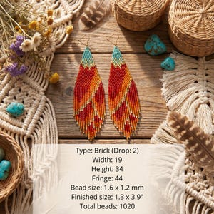 May include: A pair of long, teardrop-shaped beaded earrings featuring a gradient pattern of turquoise, orange, and red glass beads. The earrings measure 1.3 by 3.9 inches, with a brick stitch construction, 19 beads wide, 34 beads high, and 44 fringe beads.
